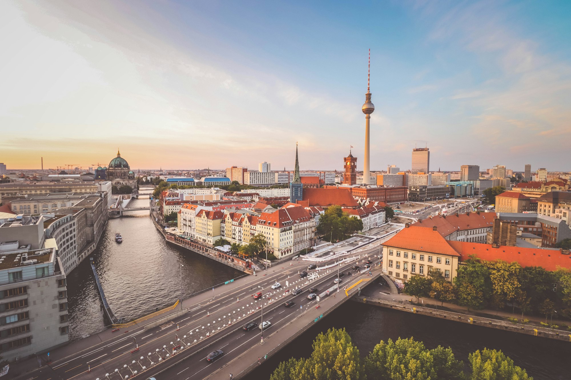 Berliner Stadtpanorama mit Fernsehturm und Spree im warmen Abendlicht.